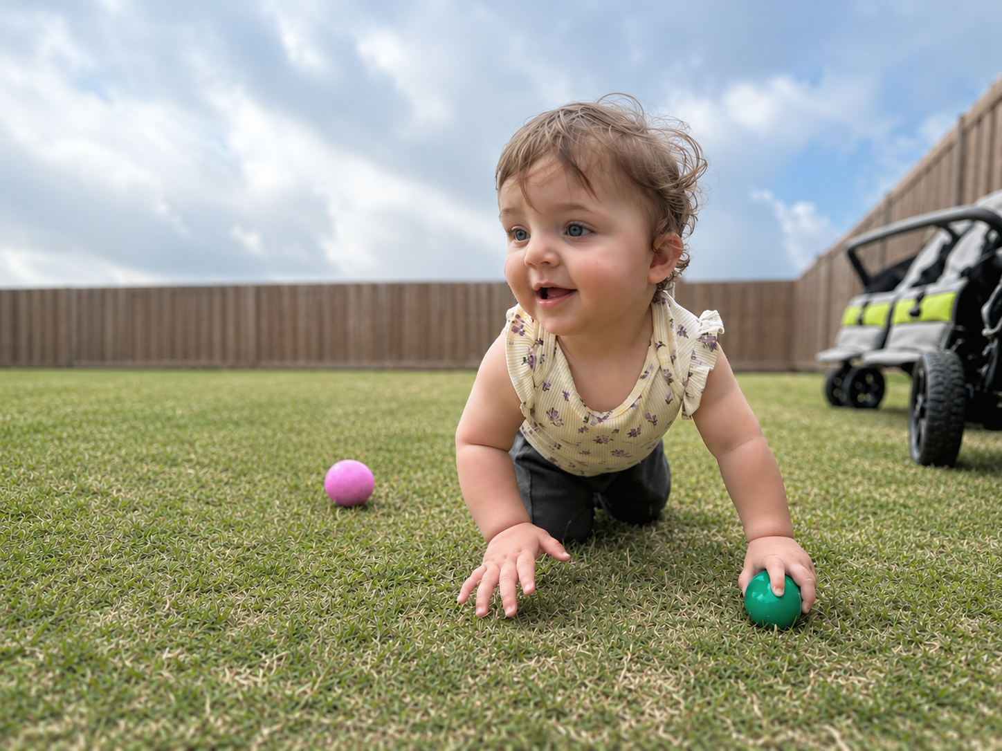 Baby crawling across the sunny grass playground on a clear day
